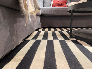 Modern living room with striped rug and cozy gray sofa near round coffee table