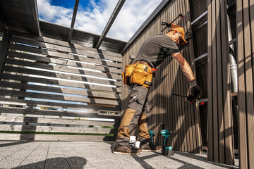 Worker Builds Structure in Outdoor Space During Daytime