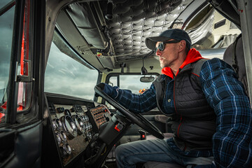 Driver Sits in Truck Cabin Looking out the Window