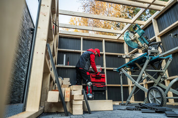 Construction Worker Organizes Tools in a Workshop Build