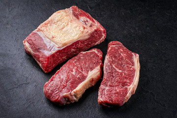 Raw dry aged  roast beef steak offered as close-up on a slate plate