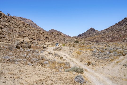 Toyota Hilux off-road vehicle on a sandy track, desert landscape with Brandberg, Erongo, Damaraland, Namibia