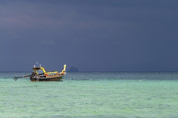 Longtail boat (Thai: Ruea Hang Yao) on the beach, behind it an approaching thunderstorm, Koh Ngai Island, Andaman Sea, Satun Province, Southern Thailand, Thailand