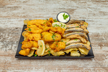 this photograph showcases the variety and color of a mixed fry with cuttlefish, dogfish, and anchovies fresh from the oil.