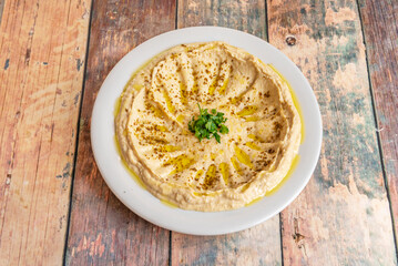 Hummus with a smoky touch, achieved with smoked paprika or chipotle, garnished with finely julienned red onion and fresh cilantro