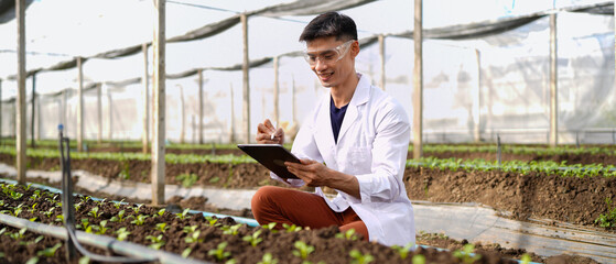 Agricultural developer handsome man trying different apps on tablet computer for advanced chemical...