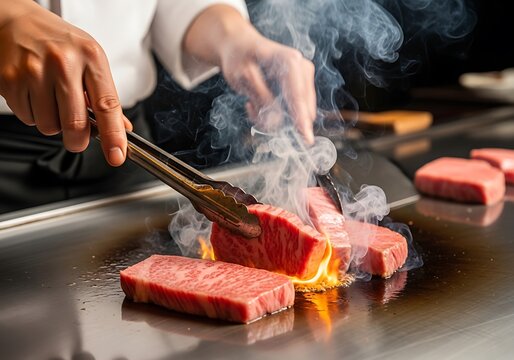 Chef cooks premium marbled steak on a hot griddle with smoke and flame.