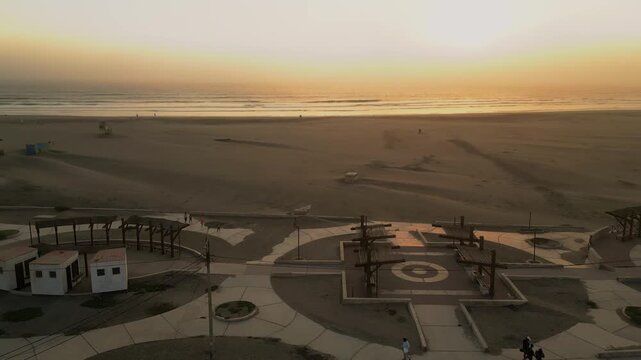 Aerial Summer Sunset at Puerto Eten, Chiclayo, Lambayeque, Golden Sandy Beach and Calm Pacific Ocean, Ideal Tropical Coastal Destination