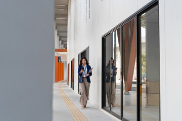 Asian businesswoman working on digital tablet with stylus outside modern building