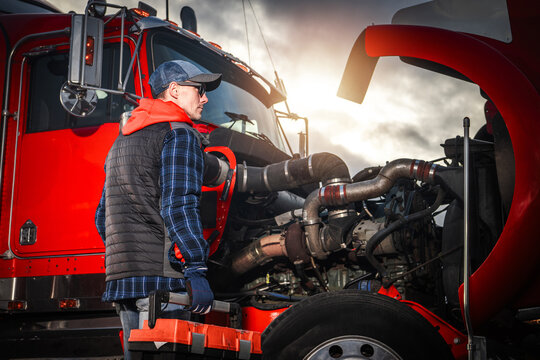 Mechanic Works on Truck Engine During Sunny Day