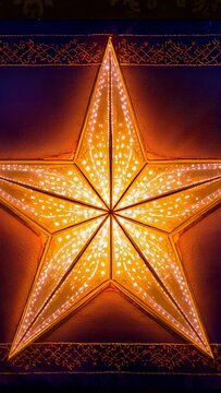 Vertical video: Pulsing five-point star with LED array driving color shifts for decor on wall