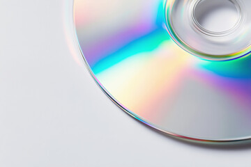 Reflective surface of a CD showing rainbow colors on a plain background in soft light
