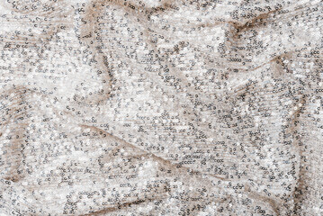 Luxury festive background with silver sequin fabric and soft glitter texture. Elegant shimmering backdrop ideal for holiday design, greeting cards, banners, marketing materials and celebrations.