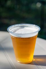 屋外イベントで提供されるプラスチックカップの生ビール（縦構図）