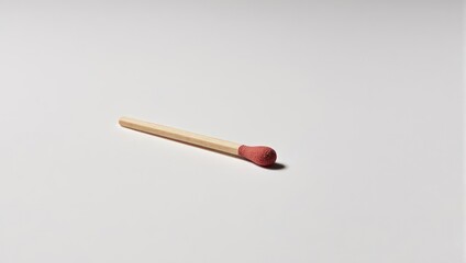 Single wooden matchstick with red tip on white background.