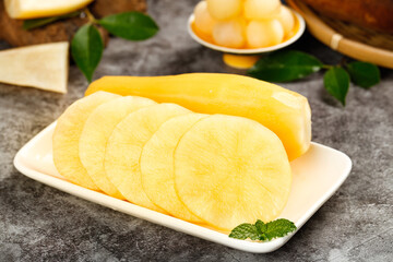 Fresh Yellow Fruit Slices on White Plate with Mint Leaves