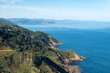 Fototapeta premium Vista panorâmica da costa rochosa de San Sebastián com o mar azul intenso do golfo de Biscaia sob um céu azul em Espanha