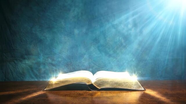 Open Holy Bible on Wooden Table Illuminated by Divine Light Ray