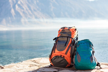 Camping backpacks by blue lake, mountains. Concept of travel, vacation, active tourism, hiking,...
