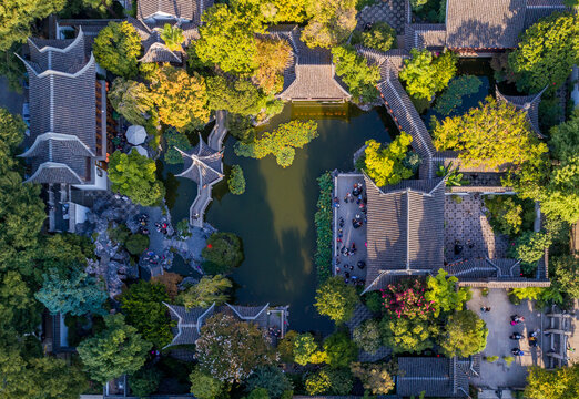 Aerial view of a tranquil pond reflecting the surrounding traditional Chinese architecture and lush greenery in the Lan Su Chinese Garden, Portland, Oregon, United States.