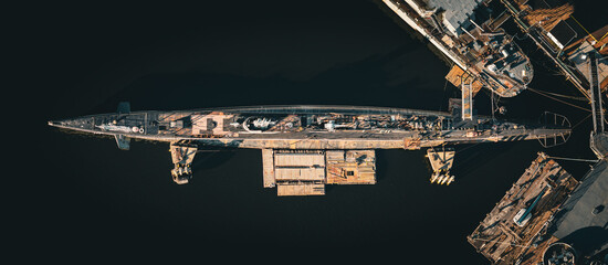Aerial view of a derelict submarine resting on support structures in dark waters, surrounded by decaying docks, Fall River, Massachusetts, United States.