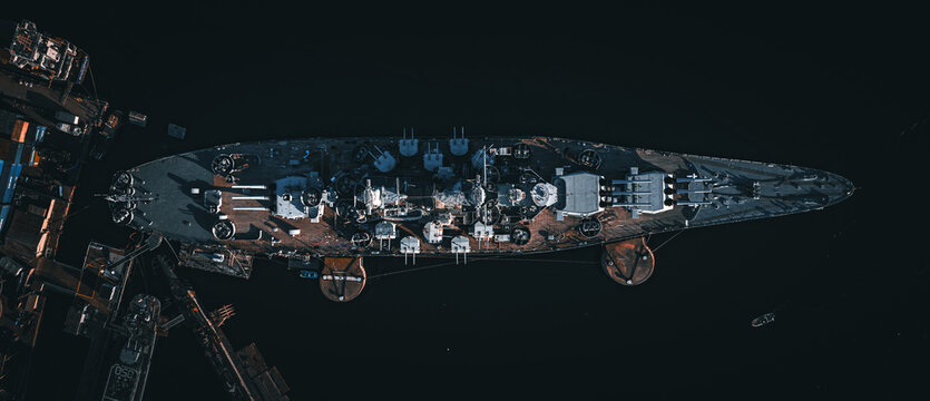 Aerial view of a battleship sits anchored in dark waters, its weathered deck a testament to time and conflict, Fall River, Massachusetts, United States.