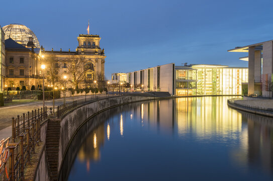 View of the Reichstag Building and modern architecture reflecting in the tranquil Spree river under the twilight sky, Berlin, Berlin, Germany.