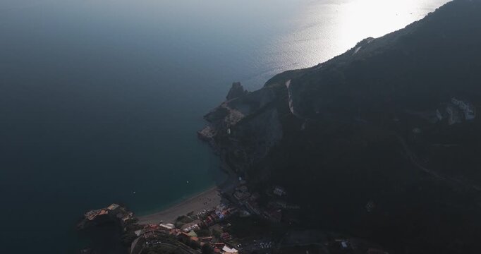 Aerial view of the coastline with mountains meeting the sea, a beach, and houses with red roofs, Erchie, Amalfi Coast, Italy.