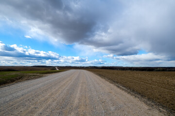 Rural dirt road under dramatic cloudy sky