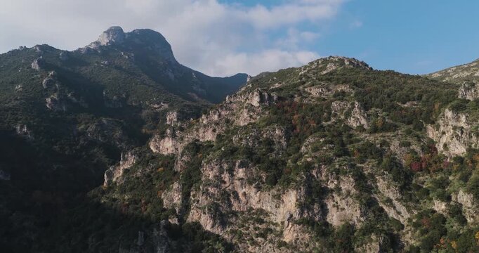 Aerial view of rugged mountains dotted with lush greenery, creating a captivating contrast against the clear sky, Erchie, Amalfi Coast, Italy.