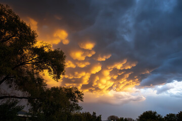 A stunning display of dramatic clouds illuminated by a vivid orange light at sunset, reflecting nature's beauty and evoking feelings of awe and wonder.