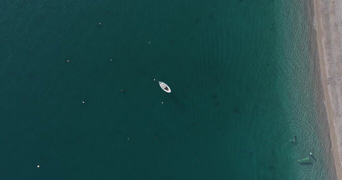 Aerial view of a boat floating peacefully on the clear, turqoise waters of the sea, creating a serene scene, Erchie, Amalfi Coast, Italy.