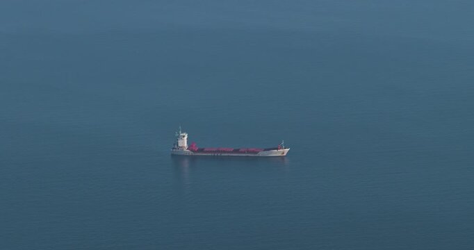 Aerial view of a cargo ship sailing on the calm, blue sea, its white hull contrasting with the water, Erchie, Amalfi Coast, Italy.