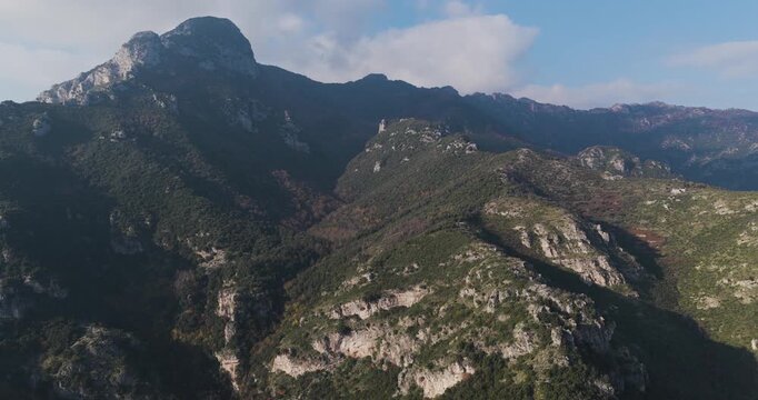 Aerial view of the rugged mountains covered with trees, the landscape creates a stunning contrast against the clear sky, Erchie, Amalfi Coast, Italy.