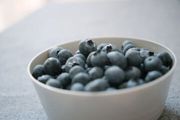 White bowl full of big ripe blueberries close up. Fresh summer berries are natural source of vitamins and microelements. Healthy eating, vegetarian diet