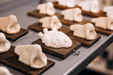 Ceramic anatomical sculptures displayed on wooden stands.