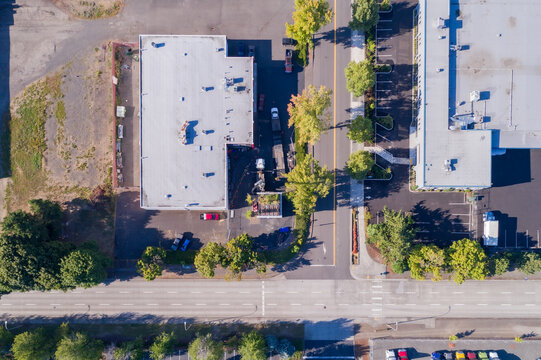 Aerial view of buildings casting shadows, with cars parked nearby and trees lining the streets, Quantum Assembly, Portland, United States.