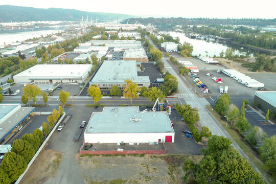 Aerial view of industrial buildings casting long shadows in the morning light, with the river reflecting the sky, Quantum Assembly, Portland, United States.