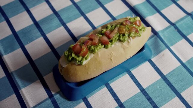 Chilean Completo Italiano Hot Dog with Avocado, Tomato, and Mayonnaise, Close-up of Traditional South American Street Food: El Completo