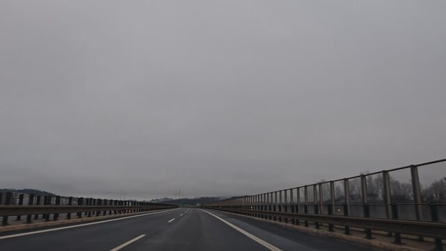 Driving on a highway from Karlovy Vary to Prague during winter, surrounded by a bleak, overcast landscape and patches of snow along the roadside.