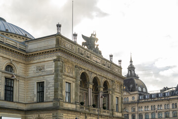 View of an ornate, sun-drenched building with arches and sculptural details stands proudly against a bright sky, Indre By, Copenhagen, Denmark.
