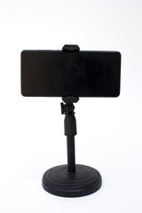 Smartphone or mobile phone in the stand, isolated on white background. Modern Mockup of a mobile phone with a dark display.