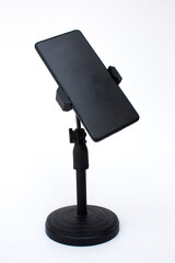 Smartphone or mobile phone in the stand, isolated on white background. Modern Mockup of a mobile phone with a dark display.