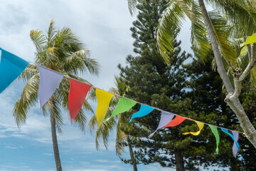 colorful garland flag on the beach and palm trees 