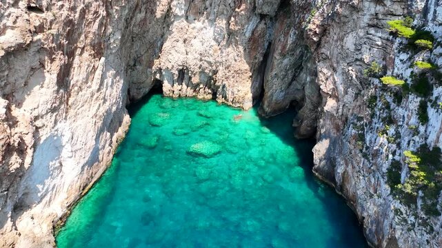 Aerial drone cinematic video of tropical exotic seascape ideal for snorkeling with sea caves and white limestone rocks resembling a blue lagoon