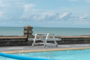 white chairs on the beach and swimming pool