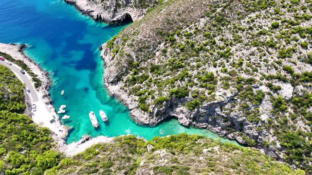 Aerial drone video of of Porto Stenitis famous fjord shaped bay with crystal clear turquoise sea and small beach  ideal for snorkeling visited by small tourist boats, Zakinthos island, Ionian, Greece