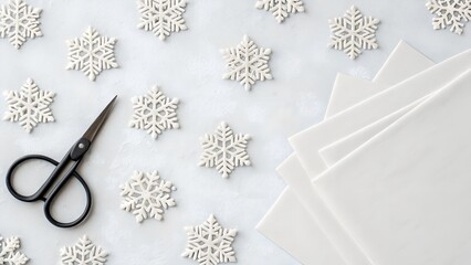 White Snowflake Decorations Scissors and Stacked Paper Sheets on Textured Gray Background Overhead View