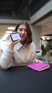 Vertical screen Office worker loses temper and throws notebook reacting angrily to wrong answers from ChatGPT during stressful work discussion on smartphone