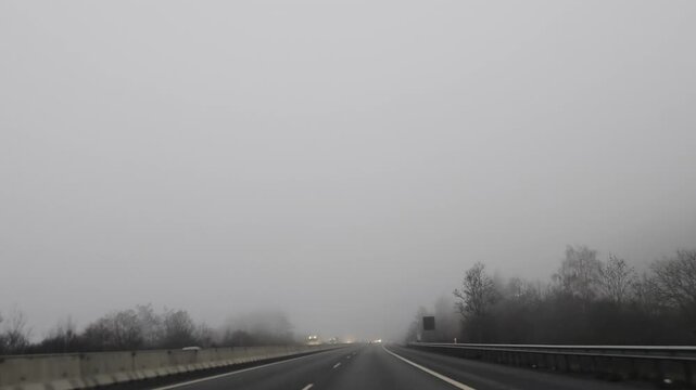 Driving on a highway from Karlovy Vary to Prague during winter, surrounded by a bleak, overcast landscape and patches of snow along the roadside.